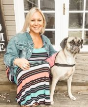 PCA NWA mental health services - A woman in a striped maxi dress and denim jacket sits on a wooden porch next to a large, light-colored dog wearing a harness.